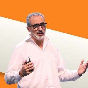 Juan Tubert mid-gesture with a clicker in hand, against an orange background